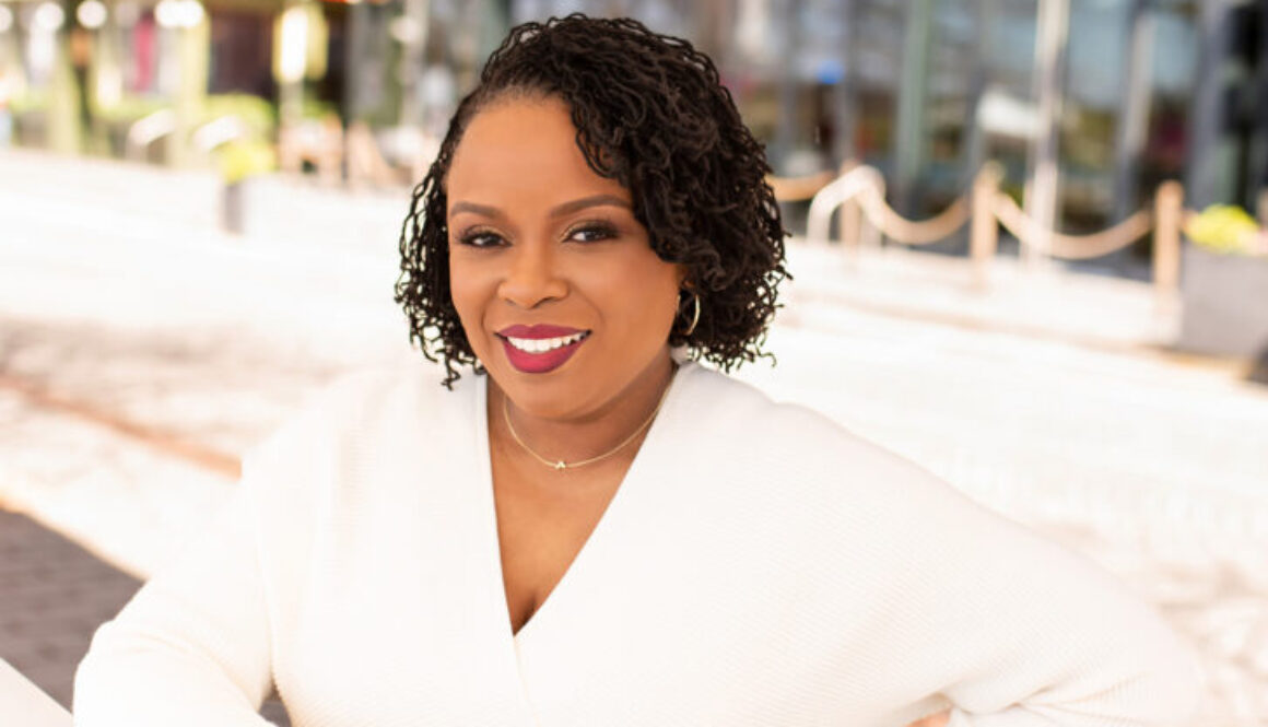 Dr. Amber L. Wright wearing a long sleeved white dress and smiling at the camera