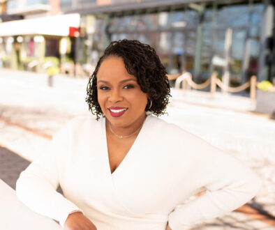 Dr. Amber L. Wright wearing a long sleeved white dress and smiling at the camera